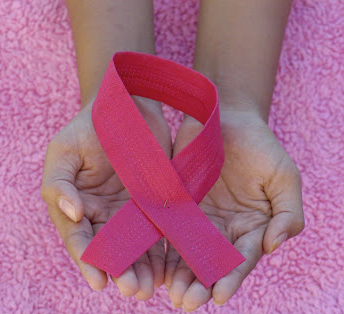 A person holding a pink ribbon