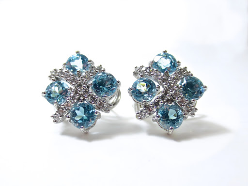 A pair of earrings with diamonds and blue gemstones